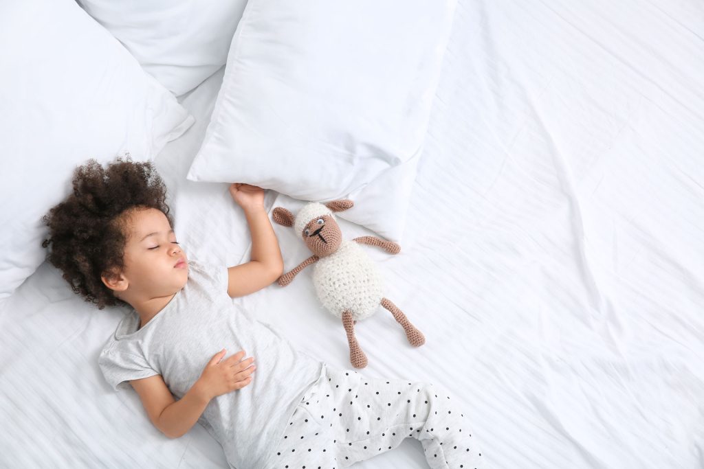 a child sleeping with a stuffed animal